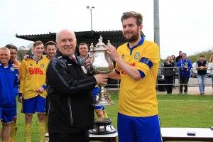 Captain Stav Roberts receives the Trophy form League Chairman Peter Maguire.